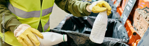 Obraz na plátně Young volunteers, in yellow safety jackets and gloves, sorting trash together with eco-conscious actions