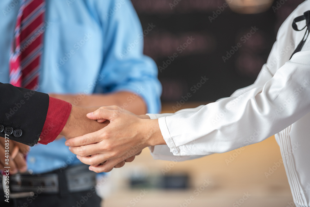 Fototapeta premium A photo of two people of different skin tones shaking hands.