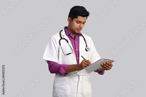 young handsome Indian male doctor with stethoscope on his neck, wearing gloves using tablet isolated on white background 