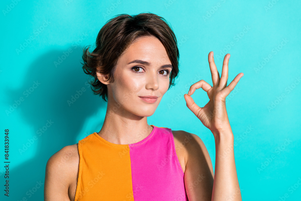 Photo of excited confident woman wear pink orange top showing okey gesture isolated teal color background