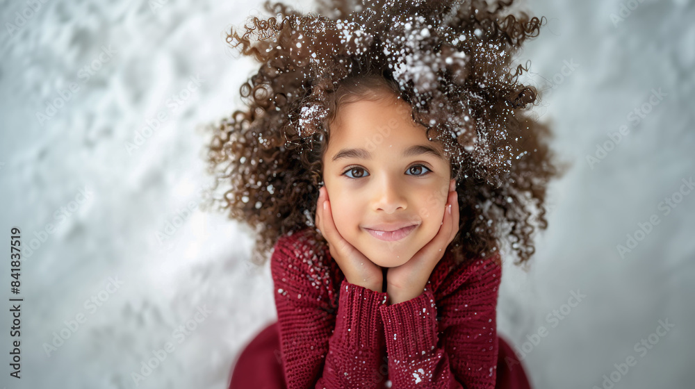Happy curly-haired girl in a knitted sweater, smiling joyfullysitting on white snow. Perfect for holiday and winter-related projects, showcasing a cheerful and festive mood. Happy curly-haired girl in a knitted sweater, smiling joyfullysitting on white snow. Perfect for holiday and winter-related projects, showcasing a cheerful and festive mood.