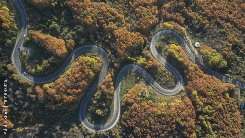 Curvy mountain roads in autumn. Vehicles in motion on winding mountain roads. Curvy mountain roads in autumn. Vehicles in motion on winding mountain roads.