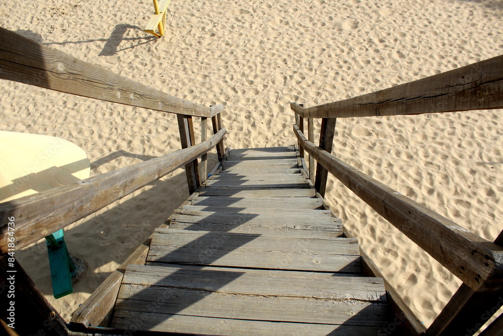 Obraz premium Top view of a wooden staircase with access to the beach sand.