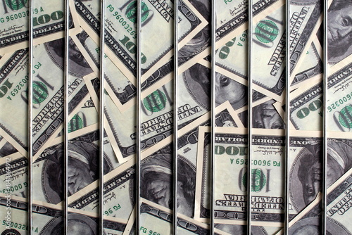 Dollars lie behind iron bars. Abstract texture.