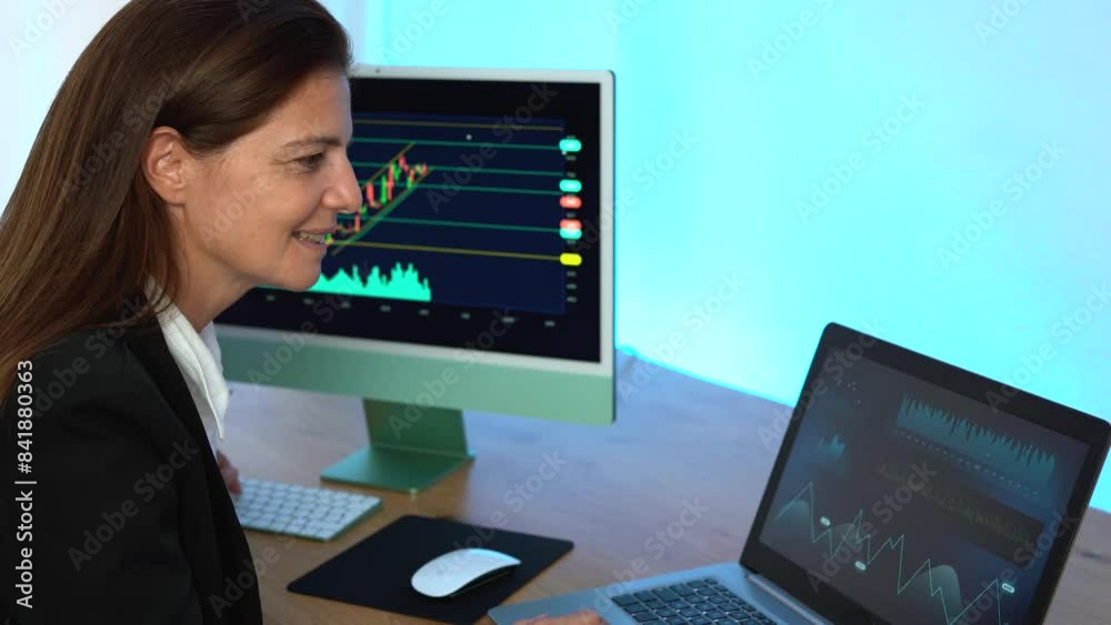 Mature trader woman working at home indoor and studying stock market - Finance, investment and trading concept Mature trader woman working at home indoor and studying stock market - Finance, investment and trading concept