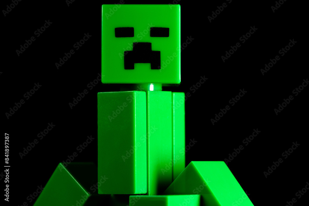 Naklejka premium LEGO Minecraft green Creeper Mob on the black background