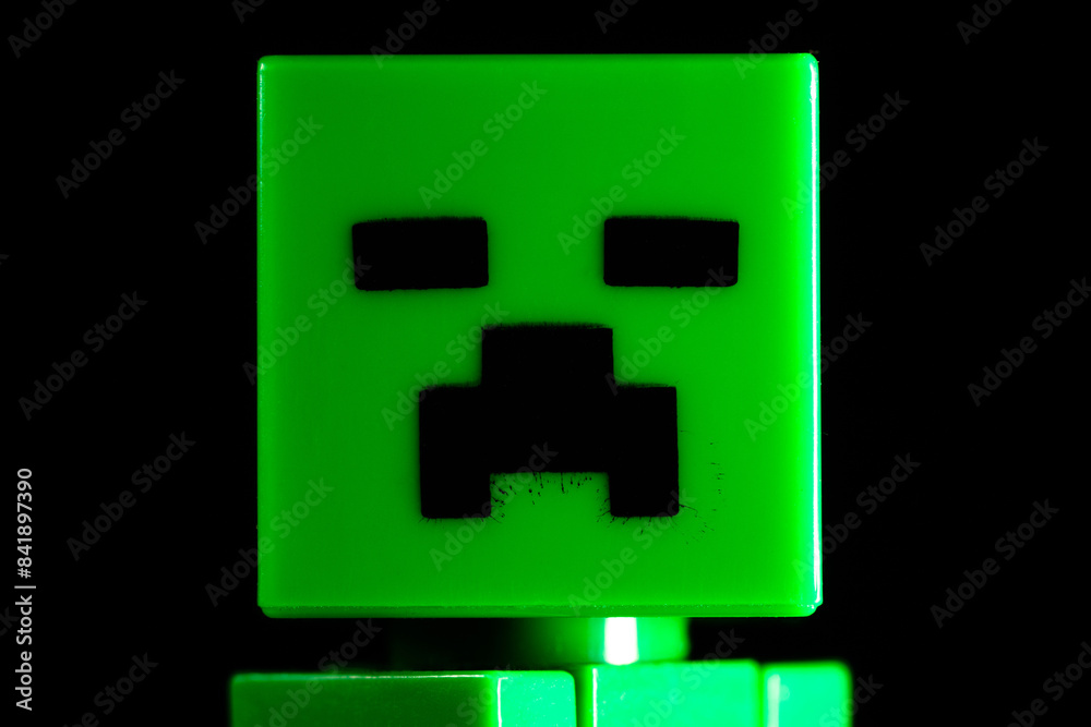 Fototapeta premium Face of LEGO Minecraft green Creeper Mob on the black background
