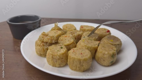 dipping chicken roll into sauce.