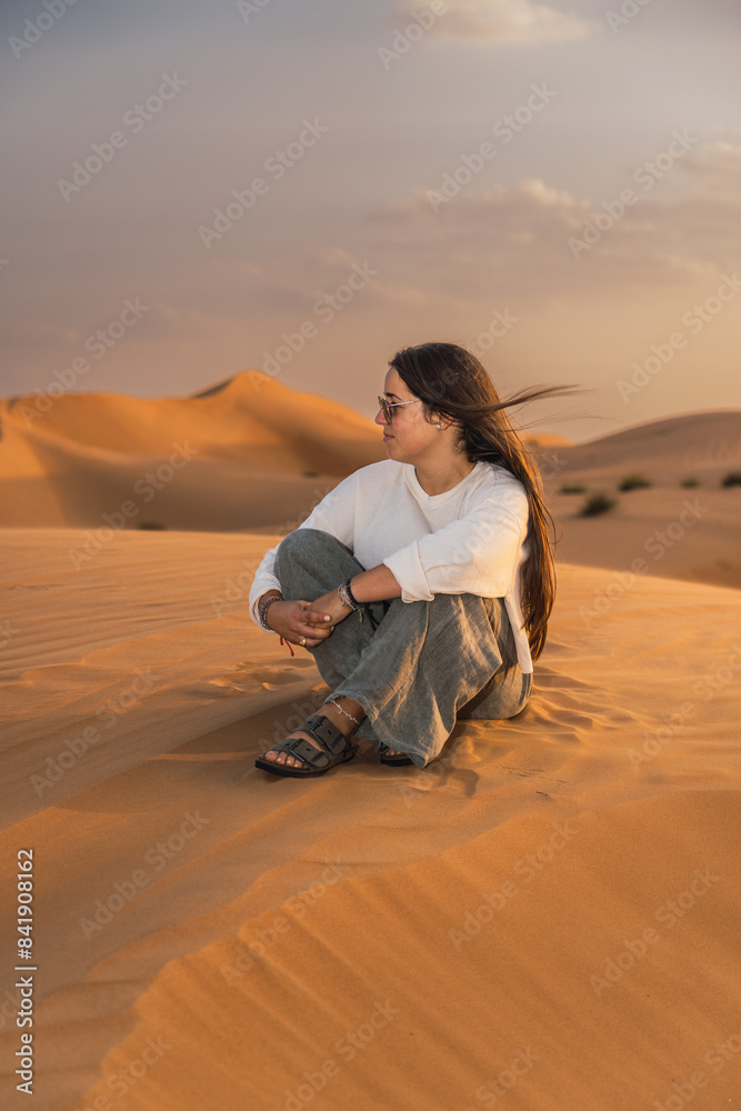 Woman serene desert sunset moment in Oman Woman serene desert sunset moment in Oman