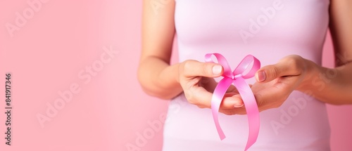 Wallpaper Mural A woman is holding a pink ribbon in her hand, which is a symbol for breast cancer awareness Torontodigital.ca