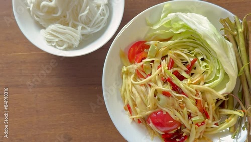 a dish of Som Tam (Spicy papaya salad) and rice noodle.