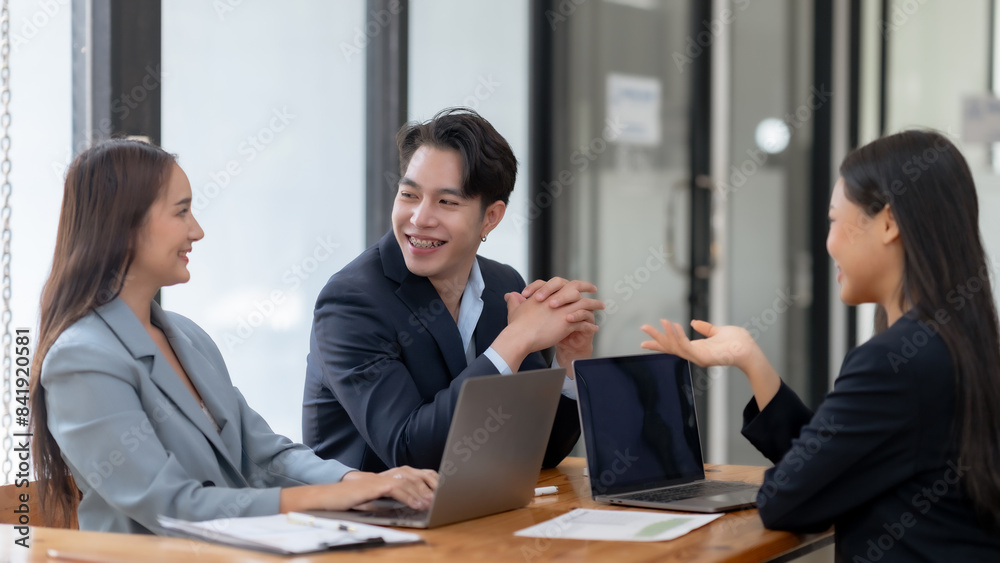 Business team discussing project in office meeting, collaborating with laptops and documents for strategy planning. Business team discussing project in office meeting, collaborating with laptops and documents for strategy planning.