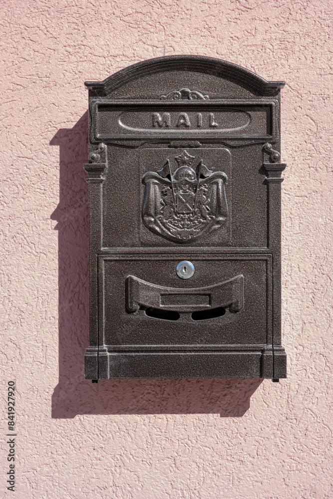 Metal mailbox on a plastered pink wall Metal mailbox on a plastered pink wall
