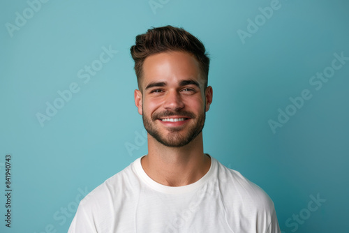 A close up portrait of a young man with a subtle smile