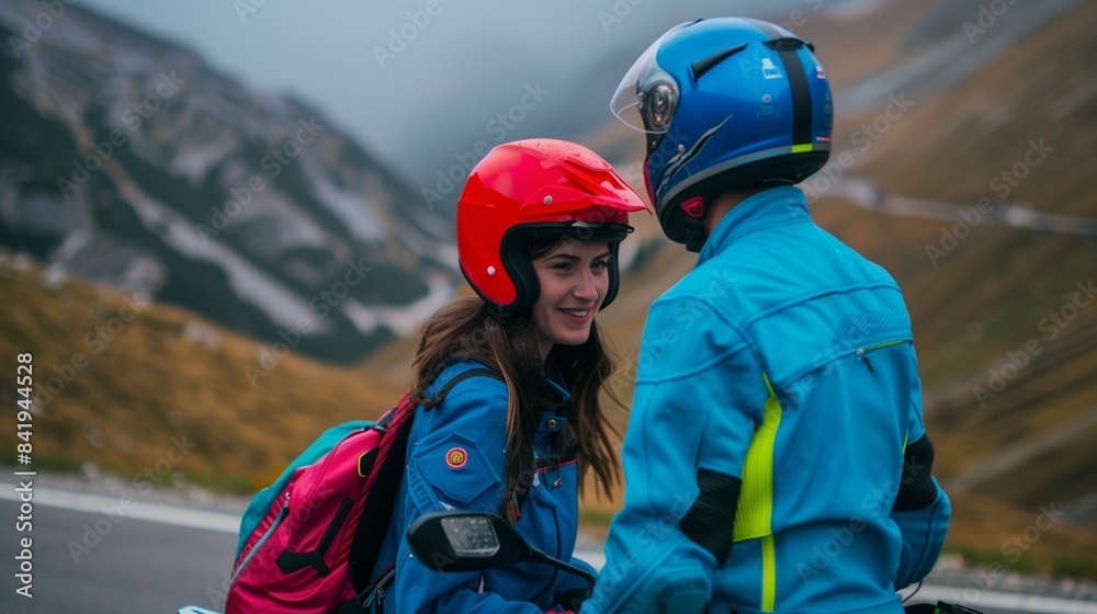 Young couple on a motorcycle adventure, woman in a vibrant red helmet, man in a neon blue jacket, scenic mountain road. Young couple on a motorcycle adventure, woman in a vibrant red helmet, man in a neon blue jacket, scenic mountain road.