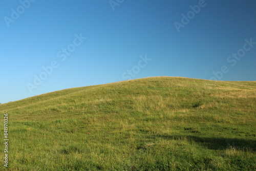 Fototapeta Naklejka Na Ścianę i Meble -  A grassy hill with blue sky