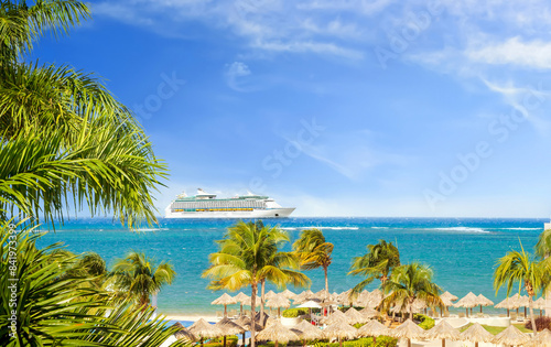 View from tropical beach on cruise ship sailing from port 