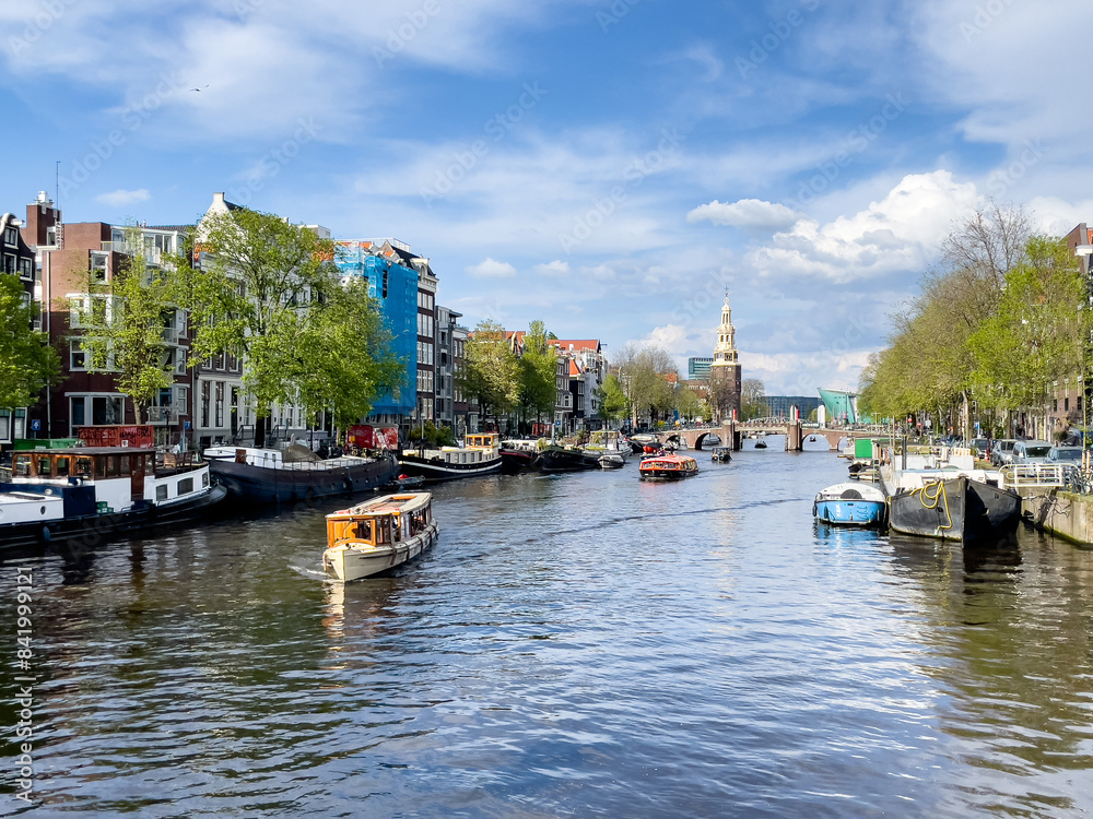 Fototapeta premium Boat tours on Amsterdam's Oudeschans canal. Traditional Dutch houses.