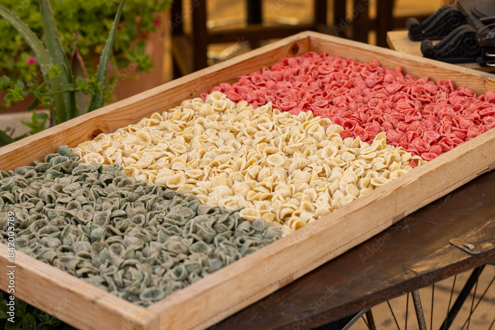 Colorful typical pasta known as orecchiette, handmade at street stands, Bari, Italy, Apulia