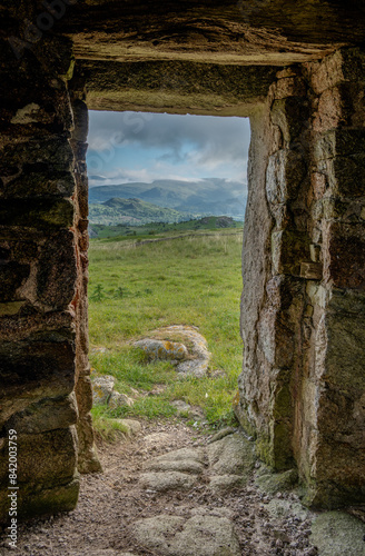 A view of the mountains through an old stone doorway photo