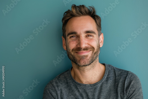 A close up portrait of a young man with a subtle smile photo