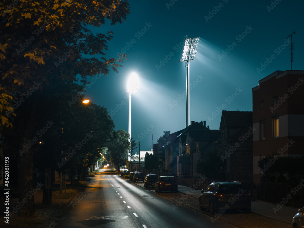 Illuminated Powstańców Chocieszyńskich street at night in Grodzisk Wielkopolski, Poland after football match at the stadium