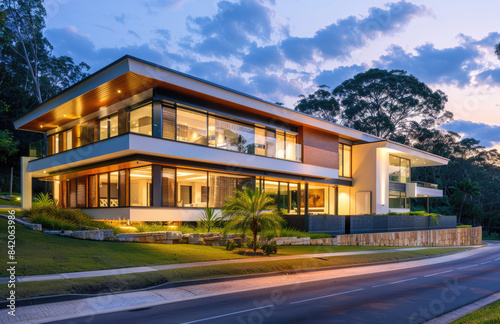 A contemporary two-story house in Sydney, Australia with flat roofs and large windows showcasing the view of a lush green parkland. Created with AI © Yabasiatu
