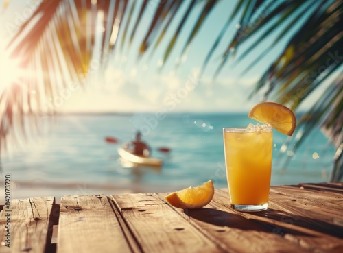 Photo of cocktail on wooden table  beach and palm tree in background