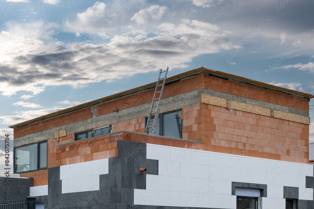 The new house construction process involves insulating the walls with modern thermal insulation materials. Exterior covering is applied at the construction site. The new house construction process involves insulating the walls with modern thermal insulation materials. Exterior covering is applied at the construction site.