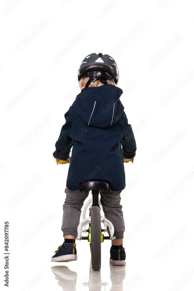 Toddler riding a balance bike while wearing a helmet for safety Toddler riding a balance bike while wearing a helmet for safety