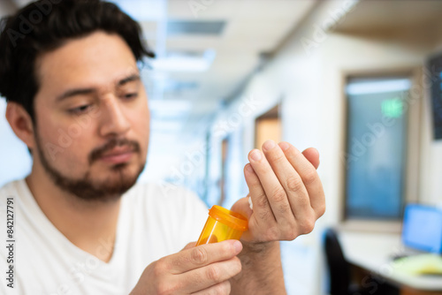 Close up of man putting many pills in his hand in a hospital room with copy space