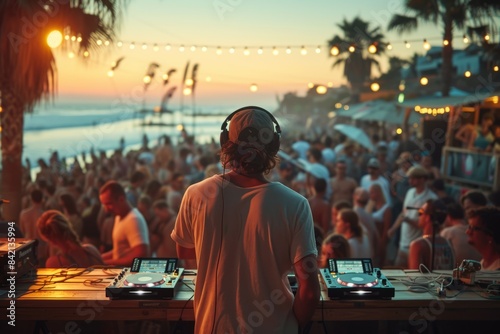 Dj looking at the beach party while playing consoles photo