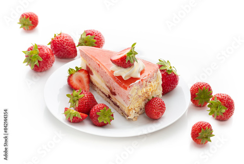 A piece of cake with strawberry souffle and fresh strawberries on a plate. Isolate on a white background