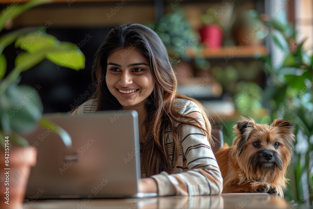 Happy Indian Woman Working on Laptop with Small Dog in Bright Home Office Happy Indian Woman Working on Laptop with Small Dog in Bright Home Office