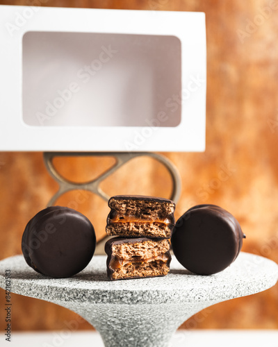 alfajor Argentino de chocolate negro relleno de dulce de leche, presentado en platoto con olas fabricado con impresion 3d photo