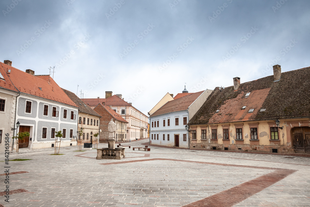 Panorama of a square in the tvrdja district of Osijek, with a typical historical austro hungarian architecture on a cloudy sky. Tvrdja is the historical fortress of Osijek, Croatia, & a major landmark Panorama of a square in the tvrdja district of Osijek, with a typical historical austro hungarian architecture on a cloudy sky. Tvrdja is the historical fortress of Osijek, Croatia, & a major landmark