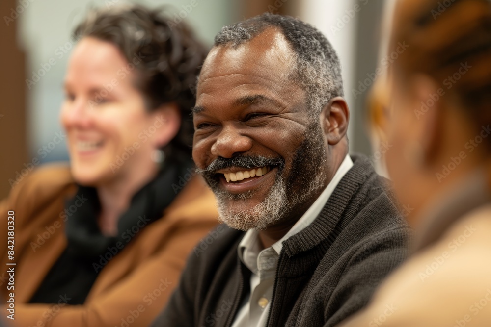 Happy senior African American man smiling and looking at camera with his friends in background Happy senior African American man smiling and looking at camera with his friends in background