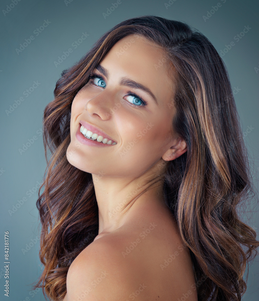 Obraz premium Portrait, hair care and woman with shine, texture and dermatology on grey studio background. Face, person and model with wellness, keratin and salon grooming with shampoo, volume and healthy scalp
