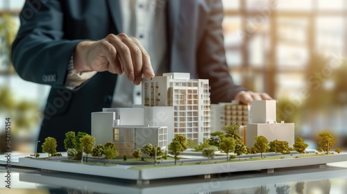 real estate development. businessman or architect showing new business office complex scale model