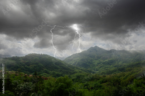 Strong lightning and rainy storm cover mountains in Asia
