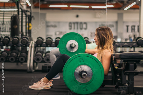two young fitness women training hip thrust in a gym