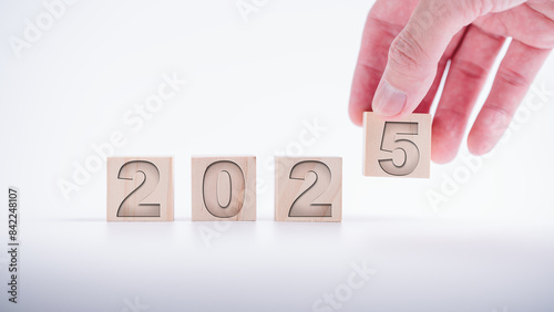 hand laying wooden cubes with the text 2025  over background. new business goal strategy concept.2025 goal planning business concept