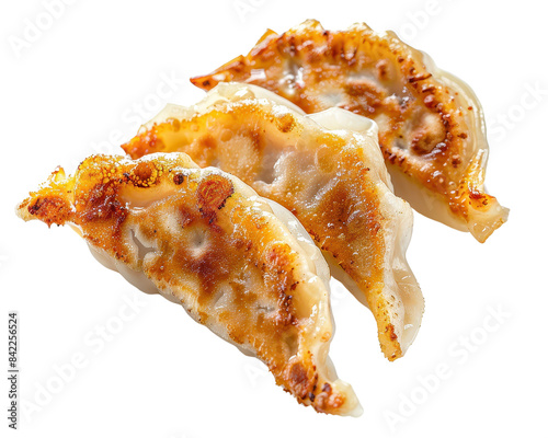 Close-up image of three delicious gyoza dumplings with golden crispy edges, isolated on white background. Perfect for food or cooking concepts.