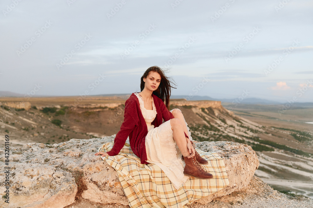 Woman sitting on rock in front of majestic mountains travel beauty in red dress fashion adventure Woman sitting on rock in front of majestic mountains travel beauty in red dress fashion adventure