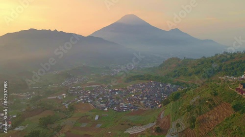 Drone view of rural landscape with beautiful scenery of mountain and sunrise sky. Tropical indonesia. Kejajar, Wonosobo, Indonesia. 4K aerial shot. photo