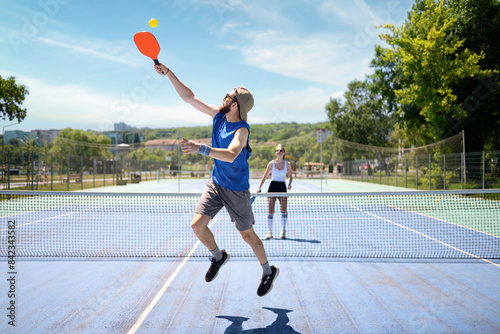 Couple playing pickleball outdoor at daylight