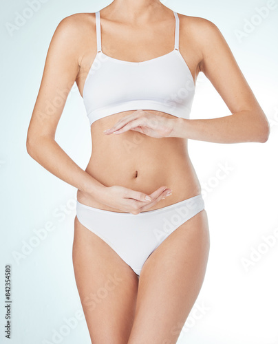 Woman, underwear and hands on stomach for probiotics, digestion or gut health in white studio background. Female person, diet and touching tummy for wellness, nutrition and balance on mockup