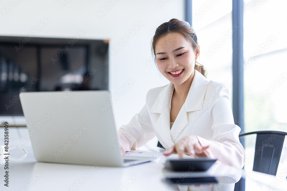 Asian Businesswoman Using laptop computer and working at office with calculator document on desk, doing planning analyzing the financial report, business plan investment, finance analysis concept.
Asian Businesswoman Using laptop computer and working at office with calculator document on desk, doing planning analyzing the financial report, business plan investment, finance analysis concept.