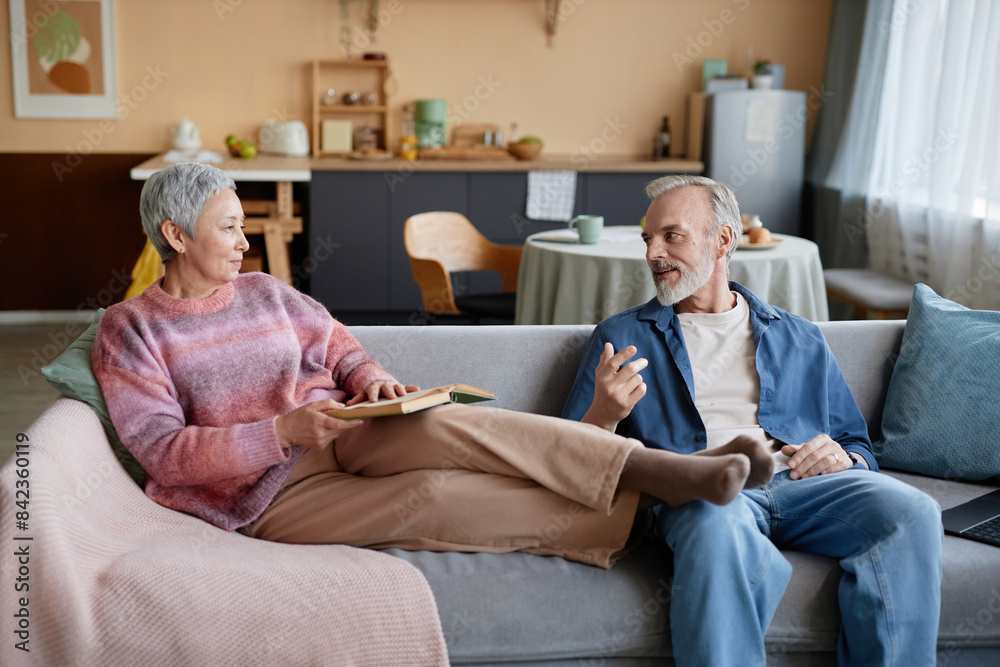 Portrait of happy senior couple relaxing at home together and chatting sitting on couch Portrait of happy senior couple relaxing at home together and chatting sitting on couch