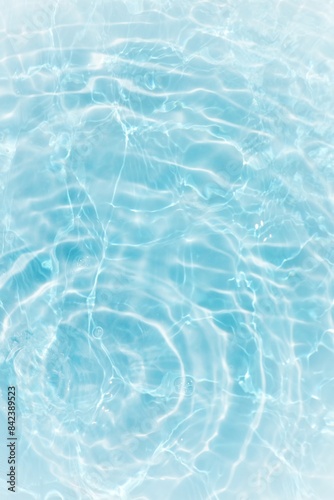 Blue water with ripples on the surface. Defocus blurred transparent blue colored clear calm water surface texture with splashes and bubbles. Water waves with shining pattern texture background. 